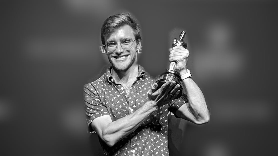 Jordan holding a prop statuette in front of a Hollywood studio-tour backdrop.
