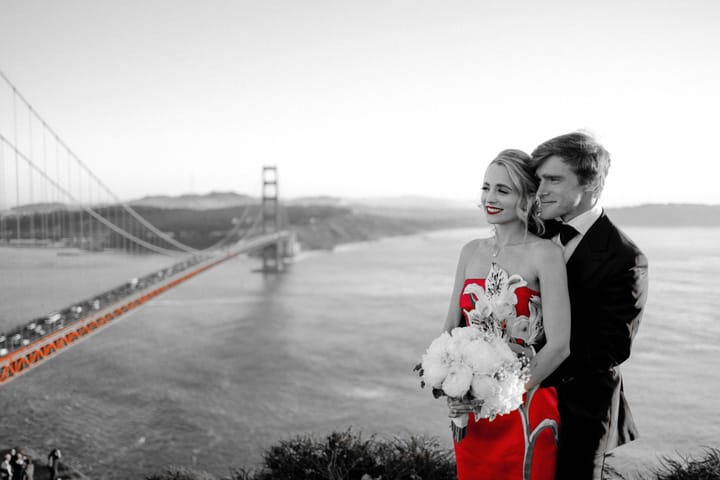 Jordan and Maria at the Golden Gate Bridge, her red dress and the bridge the only color in an otherwise black-and-white frame.